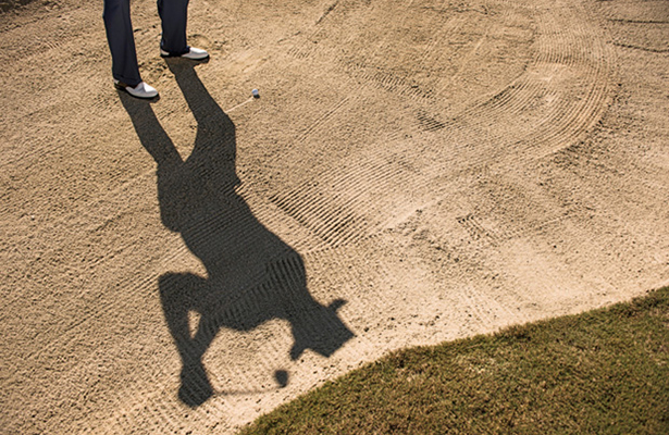 Golfer's shadow in bunker