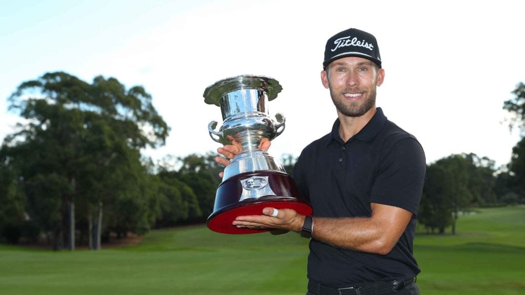 Bryden Macpherson holds trophy on golf course